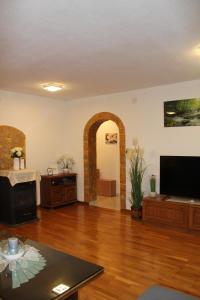a living room with a fireplace and a television at Apartments Grmaca in Trogir