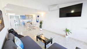 salon z kanapą i stołem w obiekcie Dúplex con vistas al mar, playa y puerto a pasos w mieście Estepona