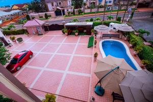 an overhead view of a pool with a car and umbrellas at Ibranad Apartments in Accra
