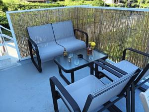 two chairs and a table with a bench on a patio at Casa Duarte, Airiños de Xil in Meaño