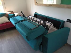 a blue couch sitting next to a bed in a room at Casa Duarte, Airiños de Xil in Meaño