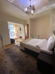 a bedroom with a large bed and a chandelier at Hotel Premium Armenia in Yerevan