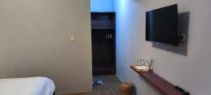 a bedroom with a bed and a flat screen tv at Tanggu ubud homestay in Ubud