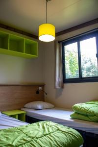 Camping Parc d'Audinac les Bains 3 étoiles - Piscine chauffée - Vue montagne客房内的一张或多张床位