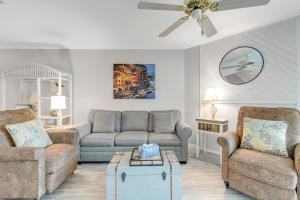 a living room with two couches and a ceiling fan at Mariners Cay 74 in Folly Beach
