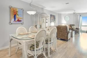 a dining room and living room with a table and chairs at Mariners Cay 74 in Folly Beach