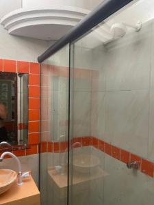 a glass shower in a bathroom with a sink at Pousada Oásis in Fortaleza
