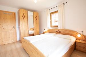 a bedroom with a large bed with a wooden headboard at Almhäuser Filzsteinalpe Almhaus 205 in Krimml