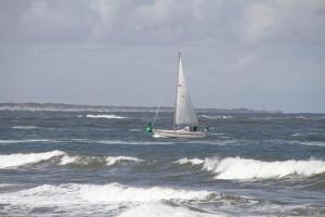 ein kleines Segelboot im Meer mit Wellen in der Unterkunft Nordstrandperle Ap H6 in Norderney + 1 Foto