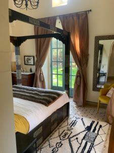 a bedroom with a canopy bed and a window at LA PORTE AU LION - Marrakech in Marrakesh
