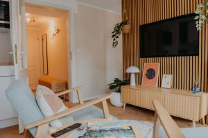 a living room with a tv on a wall at sleepArt cream in Celle