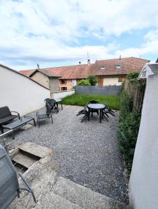 a patio with benches and a table in a yard at Studio cosy tout équipé proche de Genève in Viry