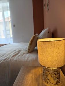 a bedroom with a bed with a yellow lamp next to it at Studio cosy tout équipé proche de Genève in Viry