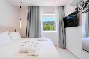 a hotel room with a bed with towels on it at Metsikas Residence in Limenas +107 photos