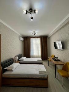a bedroom with two beds and a television in it at Best Ali Samira new hotel in Bukhara