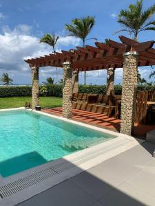 een zwembad met een houten pergola en een zwembadvisor bij Luxurious Beachfront Villa with Private Pool - Sultan Palace in Kilifi
