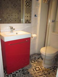 a bathroom with a red sink and a toilet at Bed and Breakfast Paris Centre in Paris