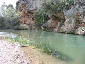 a body of water next to a rocky cliff at Casas rurales La Fuente I in Villora