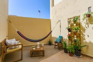 a patio with a hammock on a wall with plants at Tulum Airostel in San Isidro