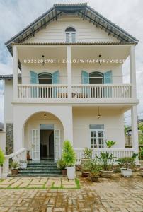 una casa bianca con delle piante davanti di Biệt Thự Khởi Nghĩa Bắc Sơn TP Đà Lạt - Gần Chợ và Hồ Xuân Hương a Xuan An