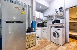a kitchen with a refrigerator and a washer and dryer at Maenam Bungalow in Mae Nam +12 photos