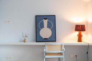 a white desk with a lamp and a chair at The Farm - Azores Boutique House in Ponta Delgada
