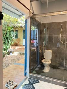a bathroom with a shower with a toilet inside at Trại Hoa Vàng Homestay at Phú Yên in Ðông Tác (1)