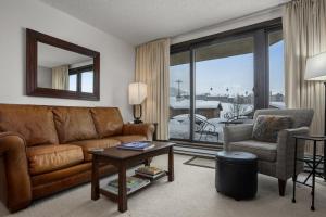 a living room with a couch and a chair and a table at Pool, Hot Tub, Sauna, Amazing Ski Area Views, Partially Covered Patio in Steamboat Springs