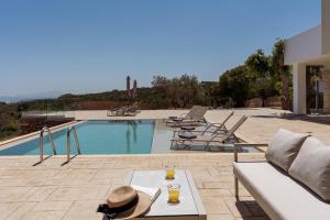 een villa met een zwembad met een tafel en stoelen bij Miroy Sea View Villa in Atsipopoulo