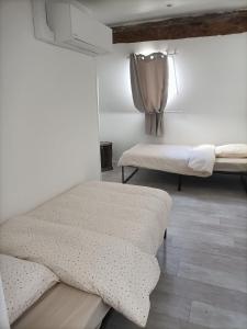 a room with two beds and a window with a curtain at Gîte du Maron in Mâron