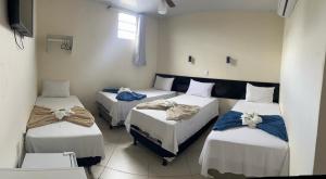 una habitación con tres camas en una habitación en Imperial Hotel Amargosa, en Amargosa