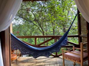 a hammock on a porch with a tree at Pousada Vila Serrano in Lençóis