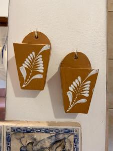 two wooden panels with white flowers on them hanging on a wall at Pousada Vila Serrano in Lençóis