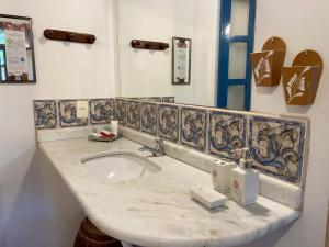 a bathroom with a sink and a counter top at Pousada Vila Serrano in Lençóis