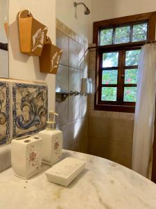 a bathroom with a shower and a sink and a counter at Pousada Vila Serrano in Lençóis