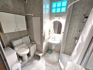 a bathroom with a toilet and a sink and a shower at Cozy Blue Apartment Prešov in Prešov +13 photos
