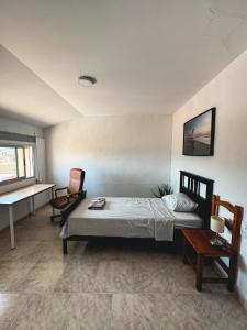 a bedroom with a bed and a chair and a desk at Casa Naranja in Palma de Gandía