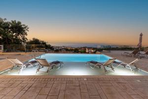 een zwembad met twee stoelen en een tafel bij Miroy Sea View Villa in Atsipopoulo