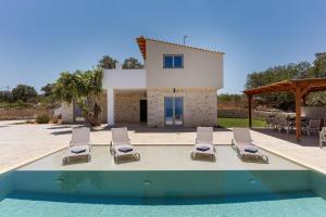 een villa met zwembad en ligstoelen bij Miroy Sea View Villa in Atsipopoulo