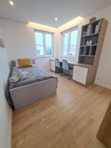 a bedroom with a bed and a desk and chairs at Casa dos Paralelos in Moledo