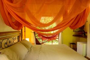 a bedroom with a bed and a window with curtains at Pousada Vila Serrano in Lençóis