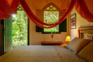 a bedroom with a bed and a large window at Pousada Vila Serrano in Lençóis