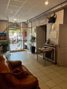 a living room with a couch and a table at Le Relais De La Poste in Pithiviers