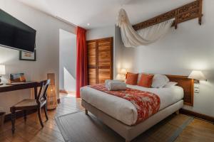 a bedroom with a bed and a desk and a television at Villa Kerasy Hotel Spa in Vannes