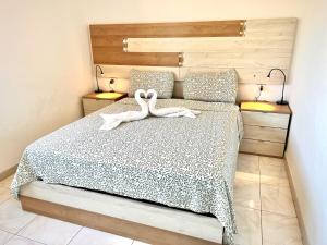 two swans sitting on a bed in a bedroom at Tropicalife in Playa del Ingles