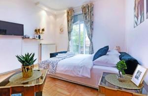 a bedroom with a large bed and two tables at Cozy apartment near Saint Sava Temple in Belgrade
