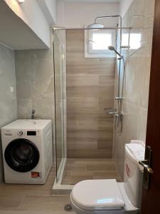 a bathroom with a toilet and a washing machine at Sikia Luxury Apartments in Sikia