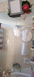 a bathroom with a sink and a mirror and flowers at cozy διαμέρισμα με υπέροχη θέα ! in Athens