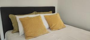 新安希亚洛斯Coralli Loft的一张带黄色枕头和黑色床头板的床