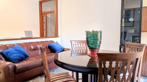 a living room with a leather couch and a table at MaisonV-Vivi il centro e il mare in Porto San Giorgio +9 photos